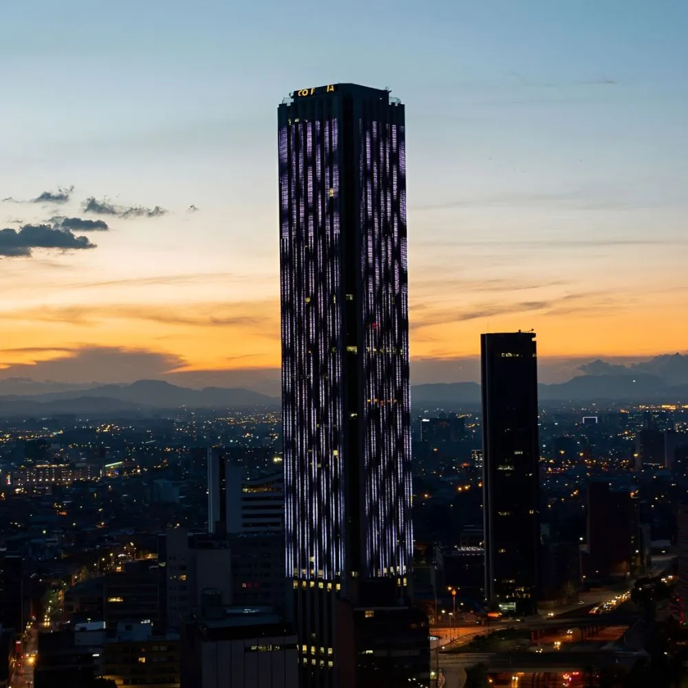 La Torre Colpatria iluminada sobre el skyline de Bogotá al atardecer: clubes swinger en Bogotá