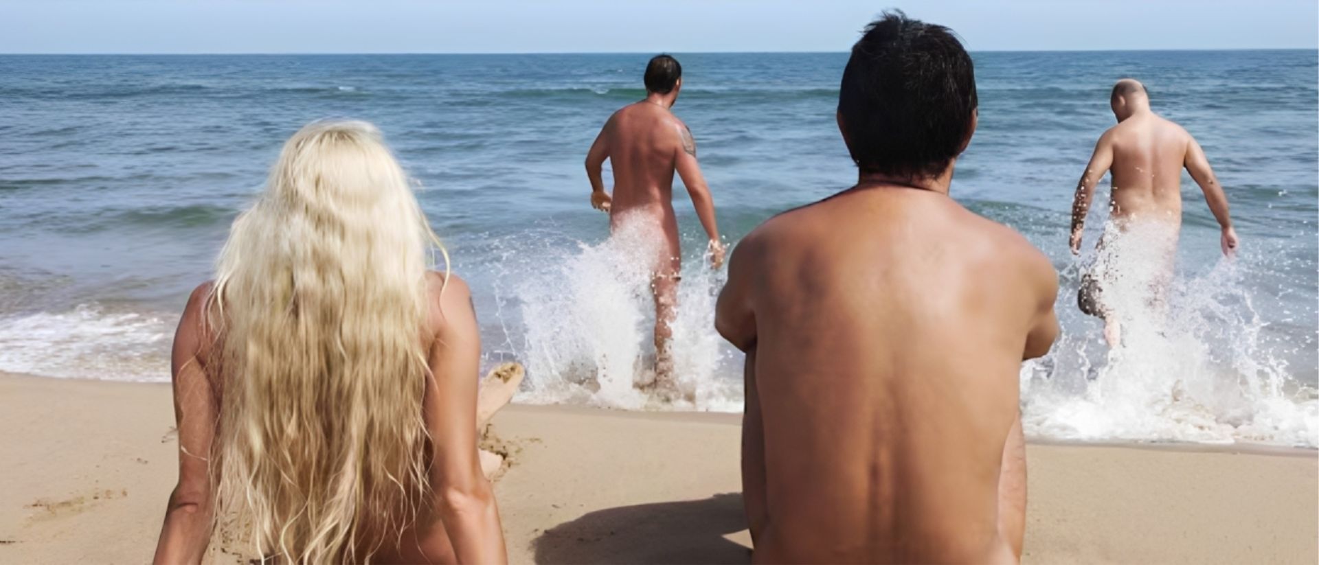 Grupo de adultos entrando al mar en una playa nudista, de espaldas, como imagen del debate legal sobre desnudez y libertad individual en Colombia