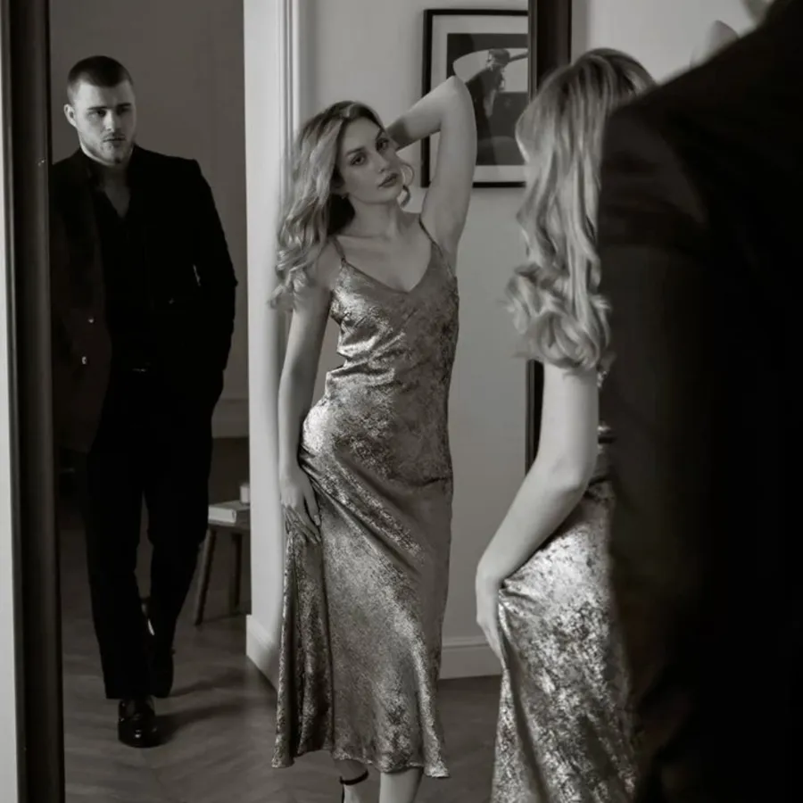 Pareja elegante frente al espejo antes de salir a un club swinger